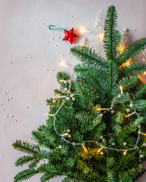 Overhead view of a flatlay conceptual Christmas tree with fairy lights and Christmas baubles