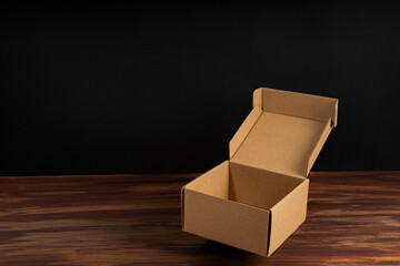 Close-up of an empty open cardboard box on a wooden table