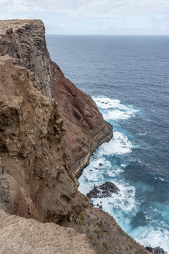 steep volcanic cliffs on ocean waves dashing  at Ponta do Rosto, Madeira