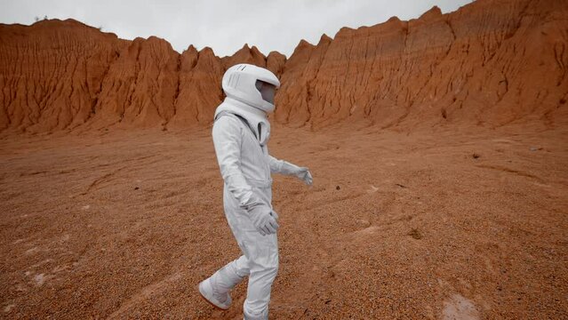 The astronaut walks on the surface of an uninhabited planet in a special suit. Conquest of new horizons. Colonization of the planet for the resettlement of mankind.