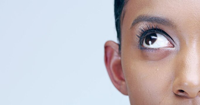 Woman, eye and close up in studio for beauty, lenses eyecare or microblading skincare. Model, face and indian girl thinking for cosmetics lashes, eyebrow makeup or eyeball care in blue bakground