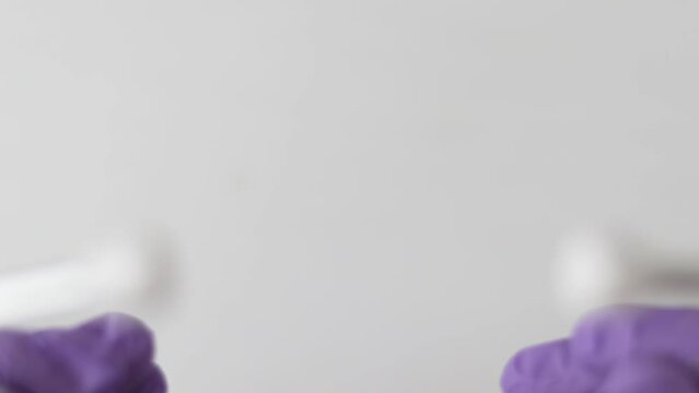 doctor hands in purple gloves putting stethoscope in ears or shows some rectal anal vaginal suppositories detach untie remove from plastic blister foil wrapper,hold in palm.slow motion step by step