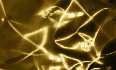 Gold foil background with light reflections. Golden textured wall.