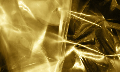 Gold foil background with light reflections. Golden textured wall.