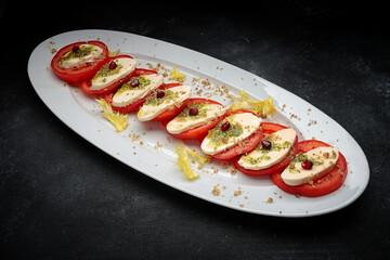 Sliced tomatoes with cheese and garlic sauce on a plate