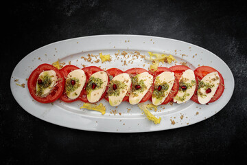 Sliced tomatoes with cheese and garlic sauce on a plate