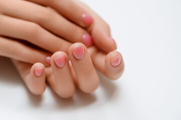 Hands of a beautiful woman on a white background. Delicate hands with natural manicure, clean skin. Light pink nails.