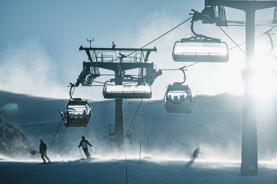 People skiing underneath ski lift in stormy conditions, Kitzsteinhorn ski resort, Sell Am Zee, Salzburg, Austria