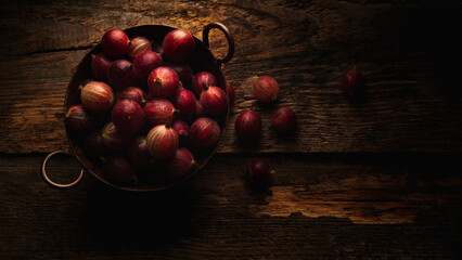 Fresh red gooseberries on rustio wooden table
