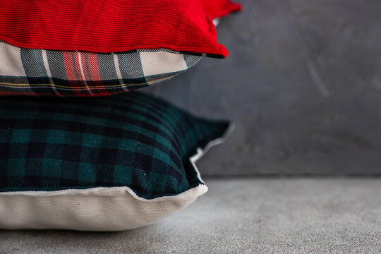 Close-up of a stack of assorted pillows with various checked patterns on a shelf