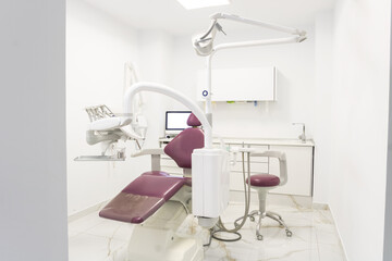 Modern pink dental clinic, dentist chair and other accessories used by dentists. The dental surgeon is a surgeon who specializes in dentistry and treatment of diseases of the oral cavity.