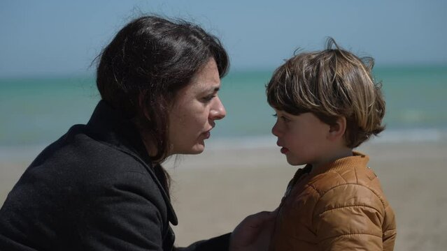 Mother scolding child for misbehaving outside. Parent educating little boy disobedience