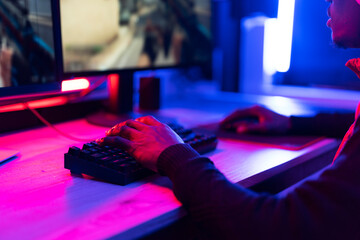 Young African man playing video game on computer. Streamer guy sitting at home and plays another match