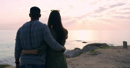 Love, sunset and back view of couple at beach, hugging and embrace. Romance, affection and interracial couple, man and woman having fun at seashore, bonding or enjoying date time together outdoors. - Powered by Adobe