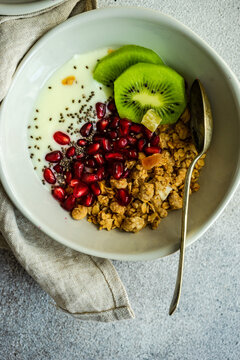 Overhead View Of A Bowl Of Yogurt With Granola, Kiwi Fruit And Pomegranate