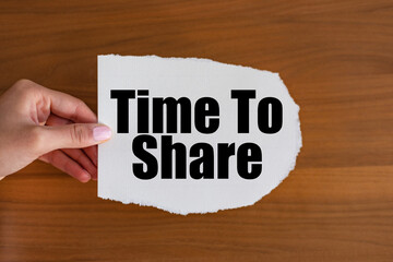 Time to share - close up text on the slip. Woman hand holds a piece of paper with text. 