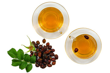 a glass cup of rosehip herbal tea on a white background, top view, along with green rosehip leaves,...