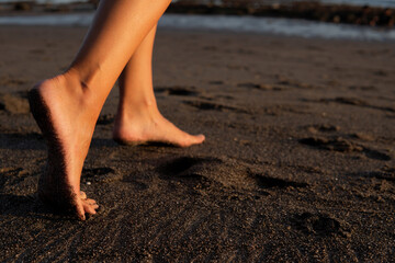 close-up. feet on black sand - Powered by Adobe