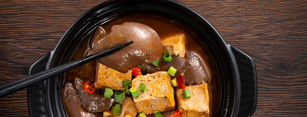 Spicy duck blood jelly soup and stinky tofu with scallion and chili pepper topping.