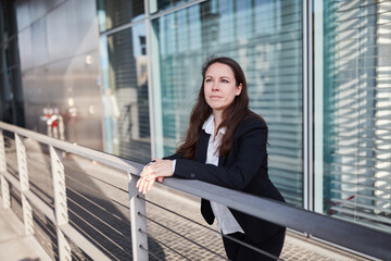 Businesswoman leaning on handrail in front of office building