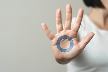 World diabetes day concept: woman shows a hand with the blue circle on it