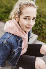 Young girl sitting on stairs looking at camera