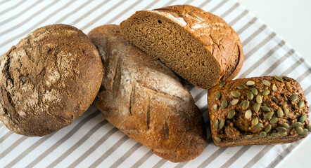 Delicious fresh bread lies on the breakfast table on a white table.