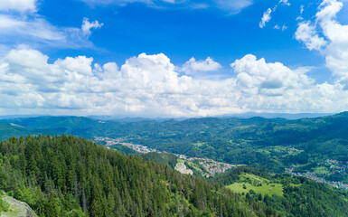 Fototapeta premium Bulgarian town Smolyan with lake, vegetation and clouds. Rhodope Mountains