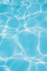 Background, blue water waves in the pool with sun reflection. Top view, selective focus