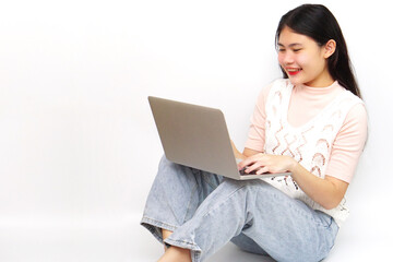 Naklejka premium Young Asian cheerful woman sitting and using laptop. Technology and learning concept.
