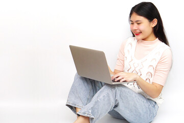 Young Asian cheerful woman sitting and using laptop. Technology and learning concept.