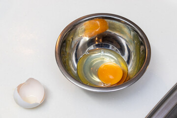金属製ボウルの中に割り入れた生卵