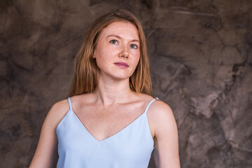 Fototapeta premium Portrait of a young red-haired woman in a dark studio