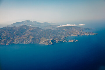 Top view of an island in the Mediterranean Sea. Image from an airplane on a mediterranean island with blue water