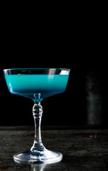 Blue lagoon cocktail with blue curacao liqueur, vodka, lime juice and soda on table
