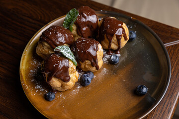 delicious profiteroles on a plate in a restaurant
