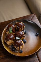 delicious profiteroles on a plate in a restaurant
