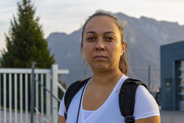 female tourist 40-45 years old with a backpack on the background of mountains and nature in summer