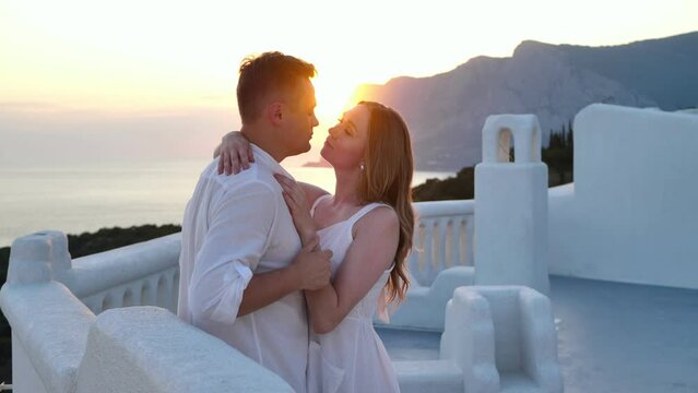 A couple of men and women in love on vacation in Santorini, Greece. A man and a woman are kissing.