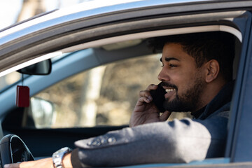 Young afro american business man using mobile phone while sitting in car