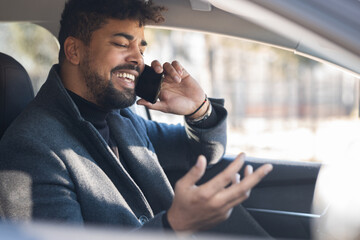 Young afro american business man using mobile phone while sitting in car