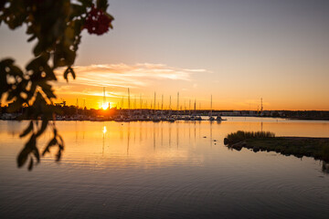 Fototapeta na wymiar Bucht mit Bootshafen in Oskarshamn Schweden. Hafen bei Sonnenuntergang. Bay with boat harbor in Oskarshamn Sweden. Harbor at sunset. Sailboats in front of sunset. 
