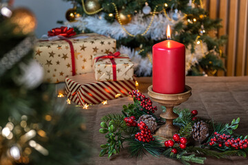 Red Christmas candle. Christmas wreath and gifts on a background with red, white, green and gold colors