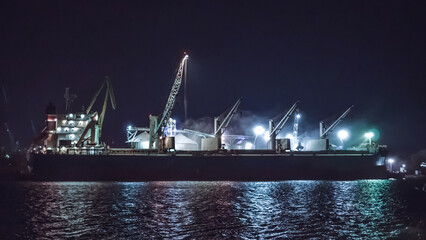 Black Sea grain export deal. Loading grain cargo vessel with grab late at night