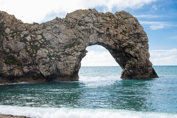 Fototapeta na wymiar Views of natural rock formations Durdle door in Lulworth, Dorset, United Kingdom. Part of Jurassic Coast World Heritage Site, view of stone arch and blue sea, selective focus