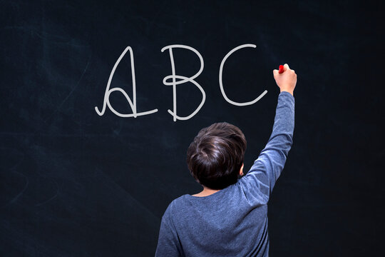 student kid writing to the blackboard