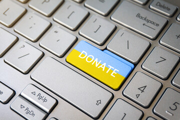 Donate text and Ukraine flag on keyboard key. Help, donations to Ukraine concept.