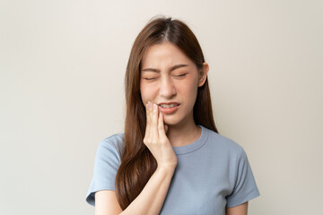 Face expression suffering from sensitive teeth, Asian young woman touching cheek