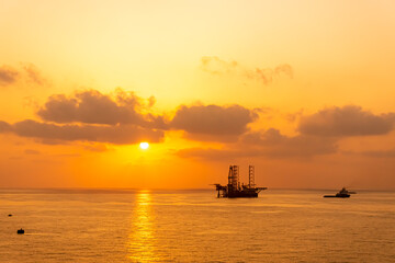 Fototapeta na wymiar Silhouette, Offshore Jack Up Rig in The Middle of The Sea at Sunset Time