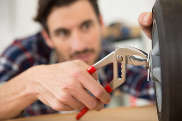 man using pliers to place a split pin